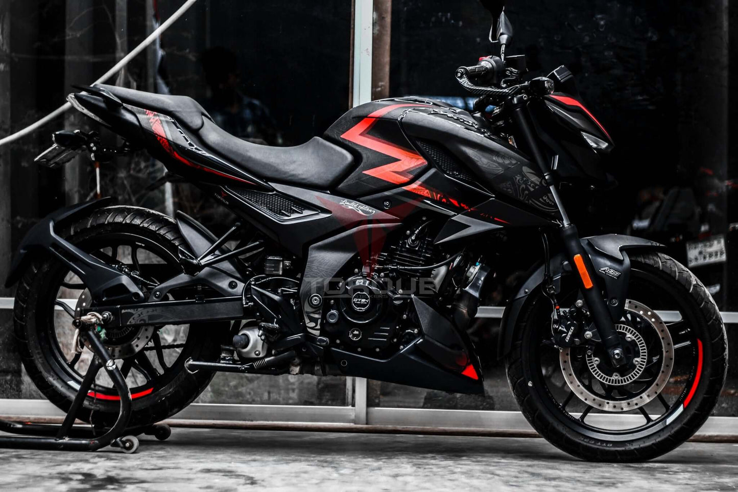 Image of a motorcycle featuring the N160 Tribal Decal Kit, highlighting bold red and black tribal patterns on its body.