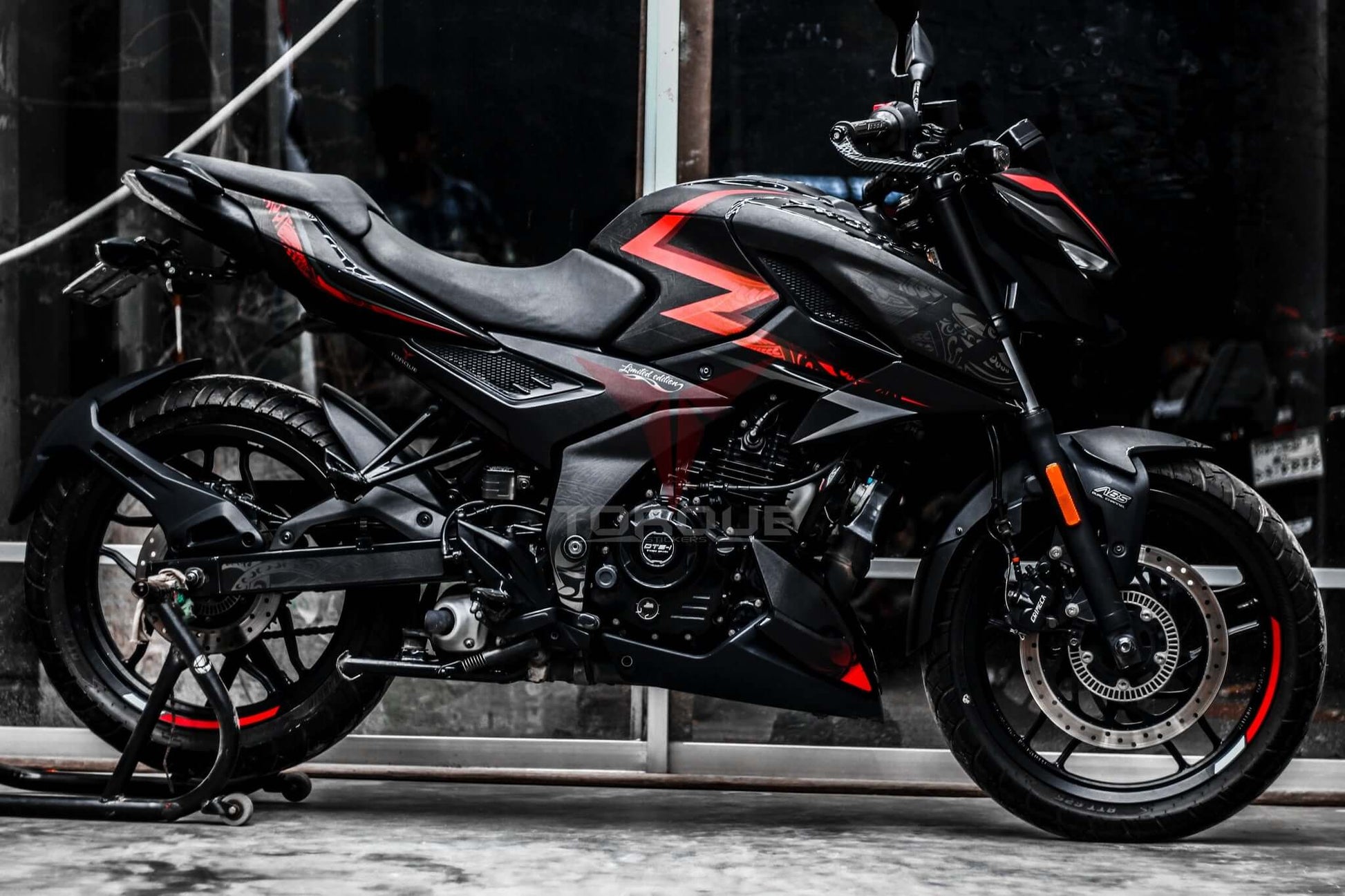 Image of a motorcycle featuring the N160 Tribal Decal Kit, highlighting bold red and black tribal patterns on its body.