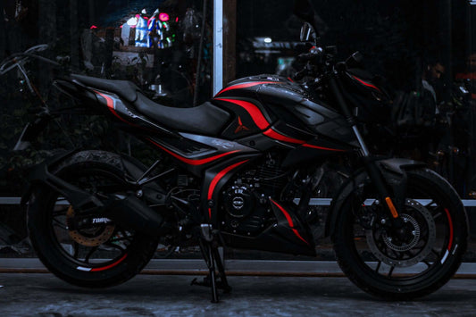 N160 motorcycle with a Wave Decal Kit featuring sleek red and black design highlights, parked indoors.