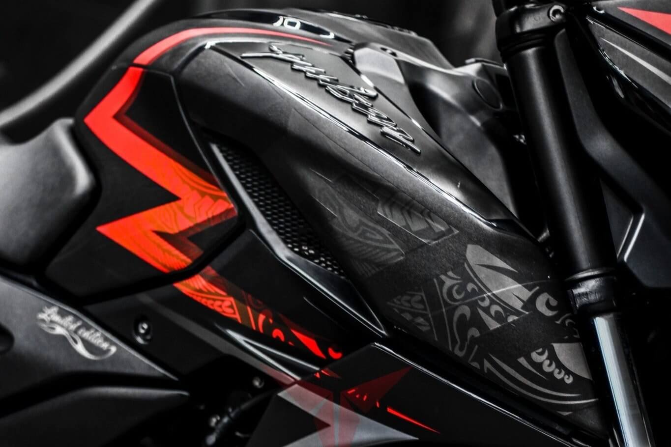 Close-up of the N160 motorcycle featuring a vibrant Tribal decal kit with red and black geometric designs on its body.