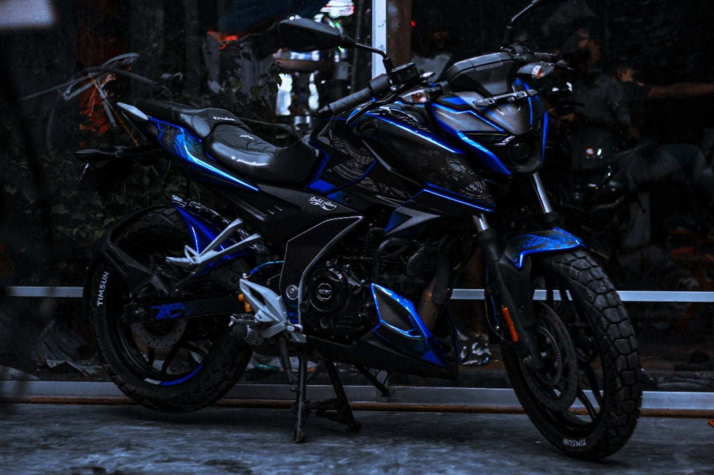 Motorbike with N160 Tribal Decal Kit, featuring blue and black graphics, parked indoors.
